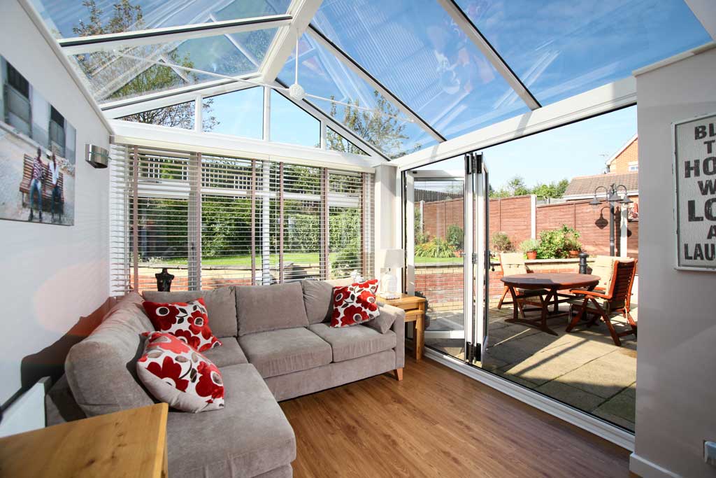 Glass conervatory and roof with open white uPVC bifold doors