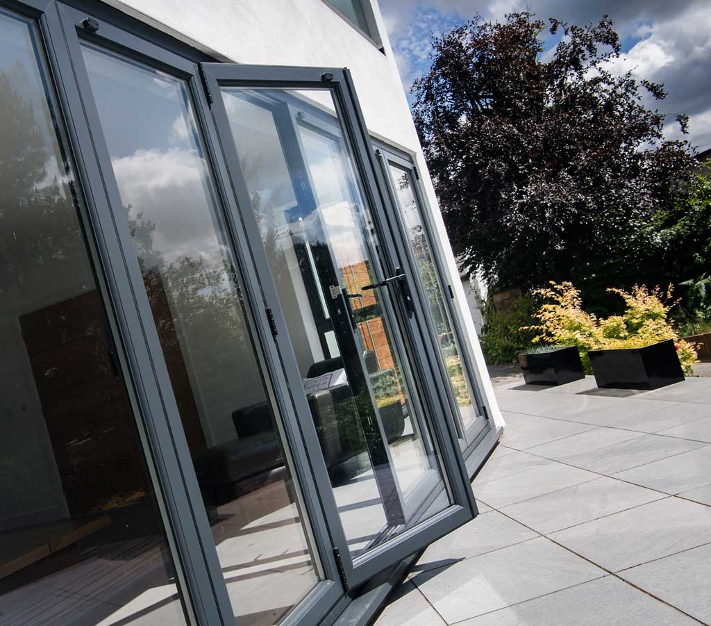 anthracite grey aluminium bifold doors partially open on a white building in newbury