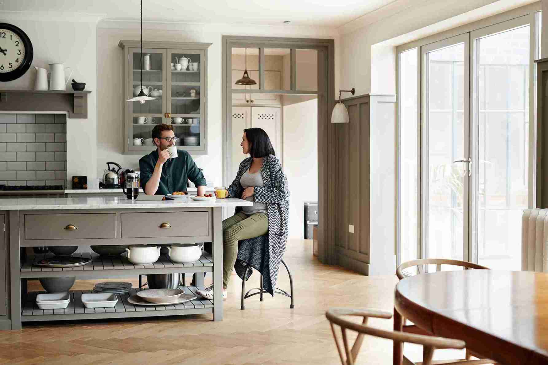 People sitting in the kitchen with Sheerline Prestige aluminium doors in Swindon