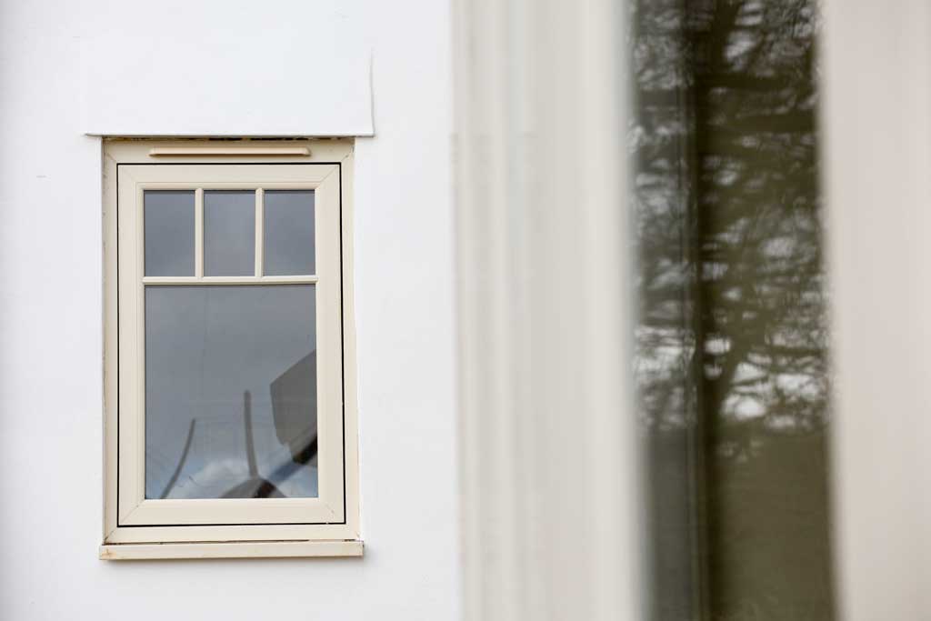 Cream triple glazed flush windows on a white wall