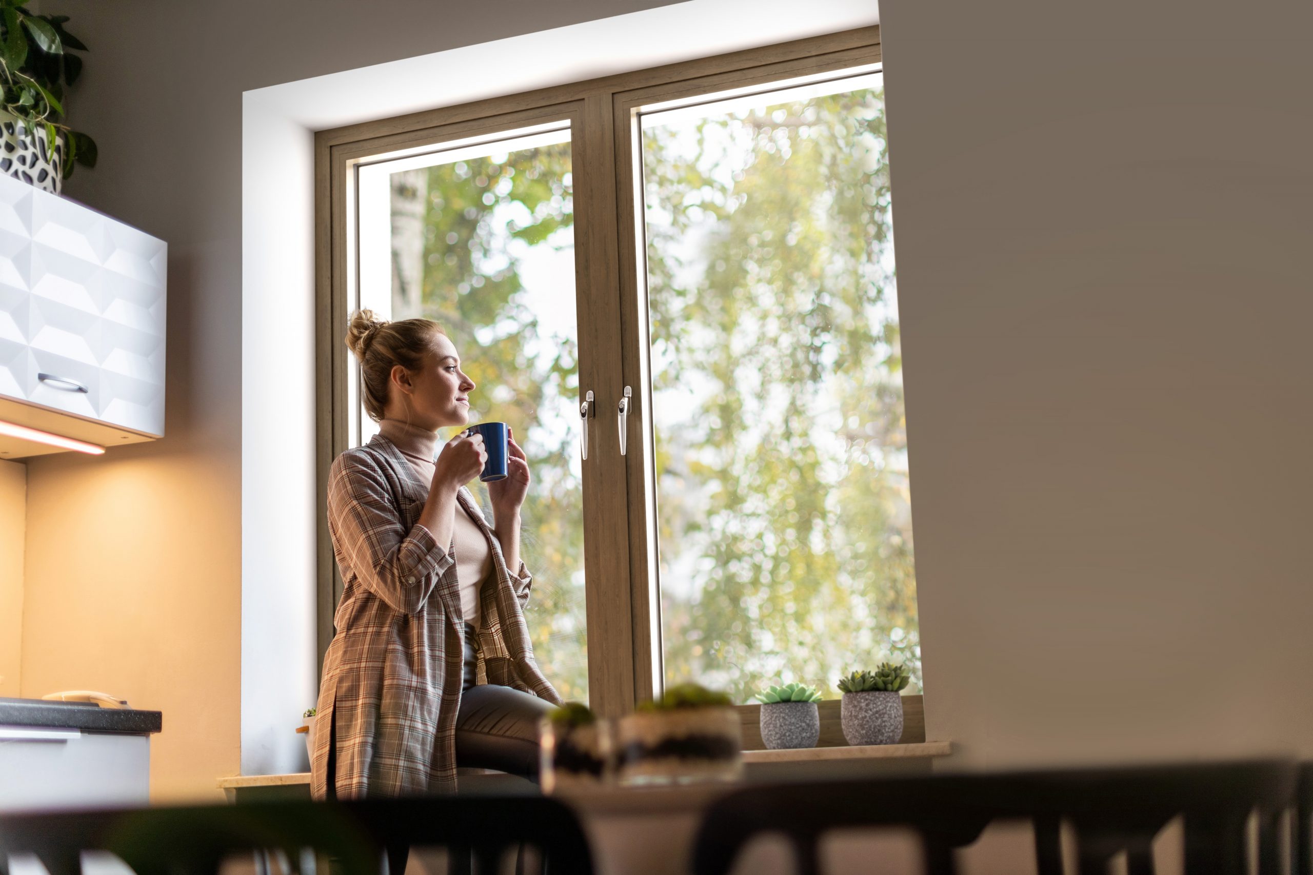 Smiling businesswoman with cup of coffee looking out of window